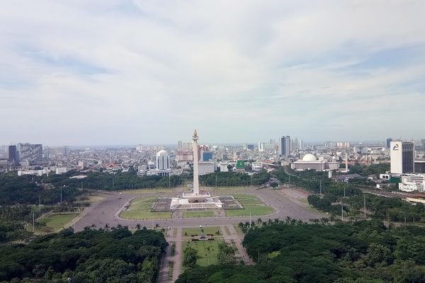 View across Merdeka Square to the tall National Monument Monas and the Jakarta skyline