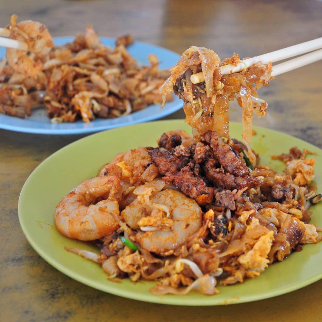 Char koay teow Ah Leng dengan telur bebek goreng di atasnya, disajikan di piring putih