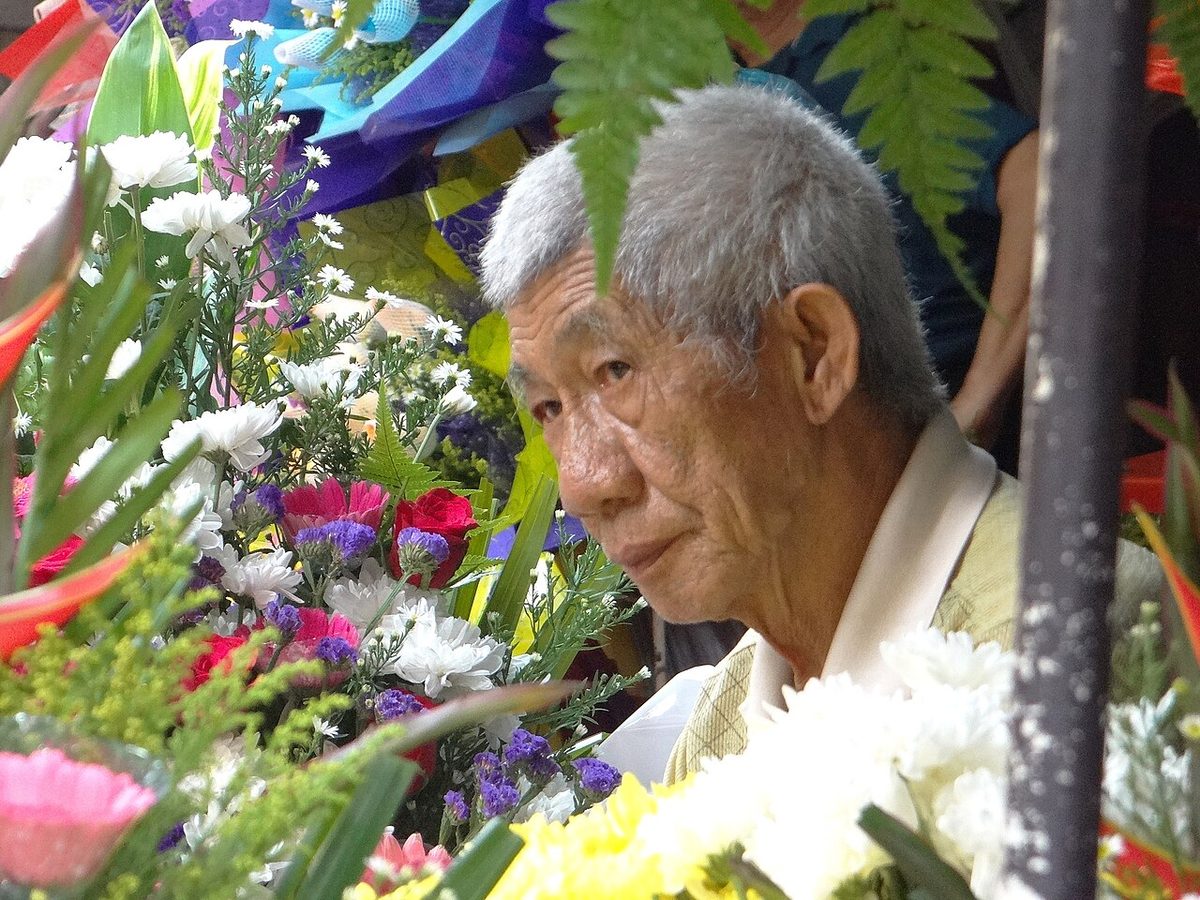 Vendor at a flower stall in Chinatown, Kuala Lumpur, surrounded by chrysanthemums, roses and other fresh flowers, a traditional florist in KL