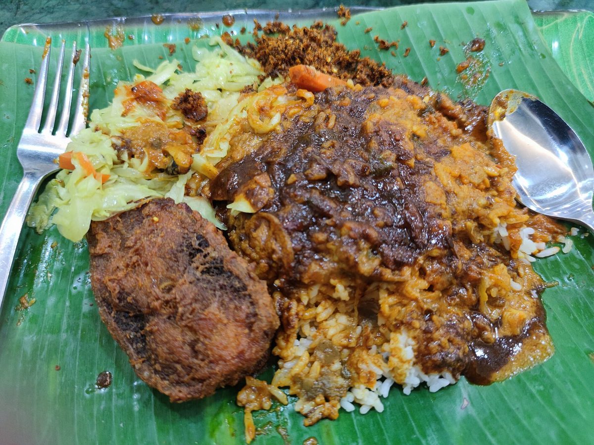 Sepinggan nasi kandar di Pulau Pinang: nasi banjir kuah kari, ayam goreng dan kobis di atas daun pisang