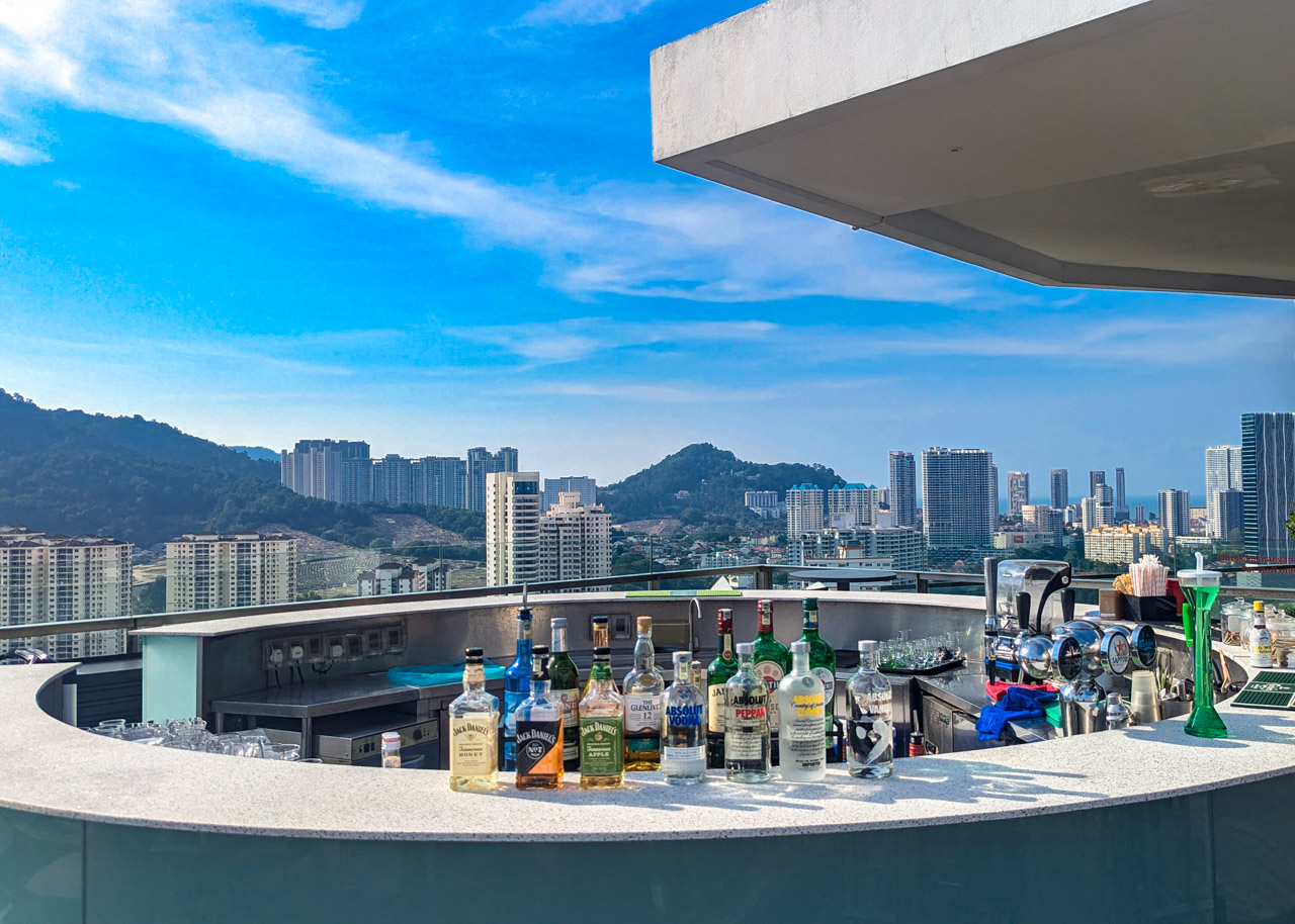 Gravity Rooftop Bar 的户外吧台，眺望槟城高楼和山丘