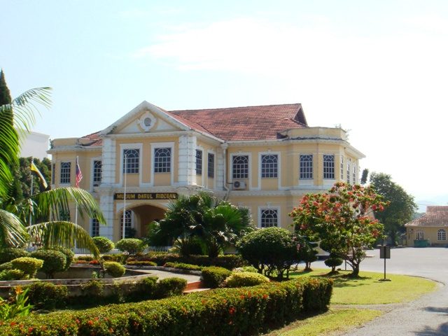 Cream-coloured colonial building of the Darul Ridzuan Museum with a landscaped garden in front