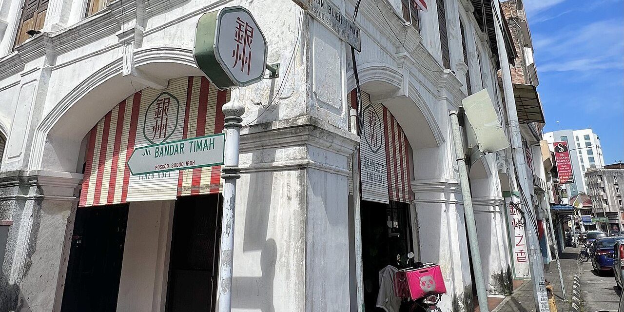 Ipoh restaurants: white colonial shophouse on a street corner in Ipoh Old Town with a Yinzo Kopi restaurant sign under the arcade