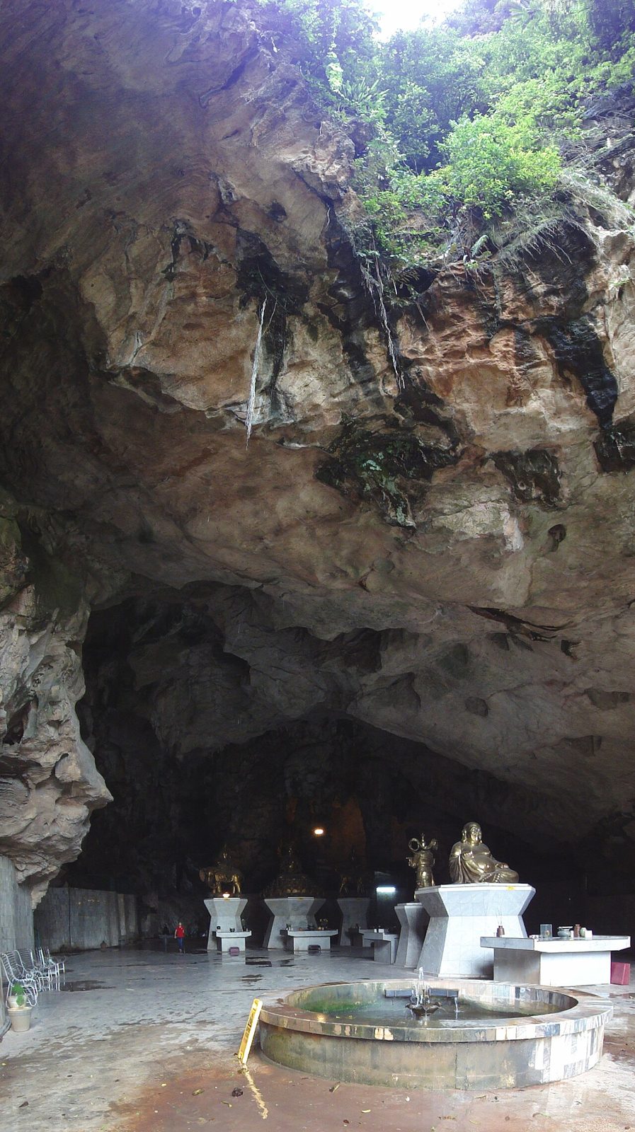 Inside the large cave of Kek Lok Tong with an altar and daylight entering through the opening above