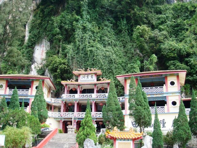 Ipoh temples: the multi-tiered Perak Tong cave temple at the foot of a forested limestone hill