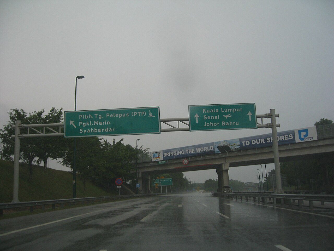 Car repair in Johor Bahru: the Second Link Expressway on a wet day, with overhead signs to Port of Tanjung Pelepas, Kuala Lumpur, Senai and Johor Bahru