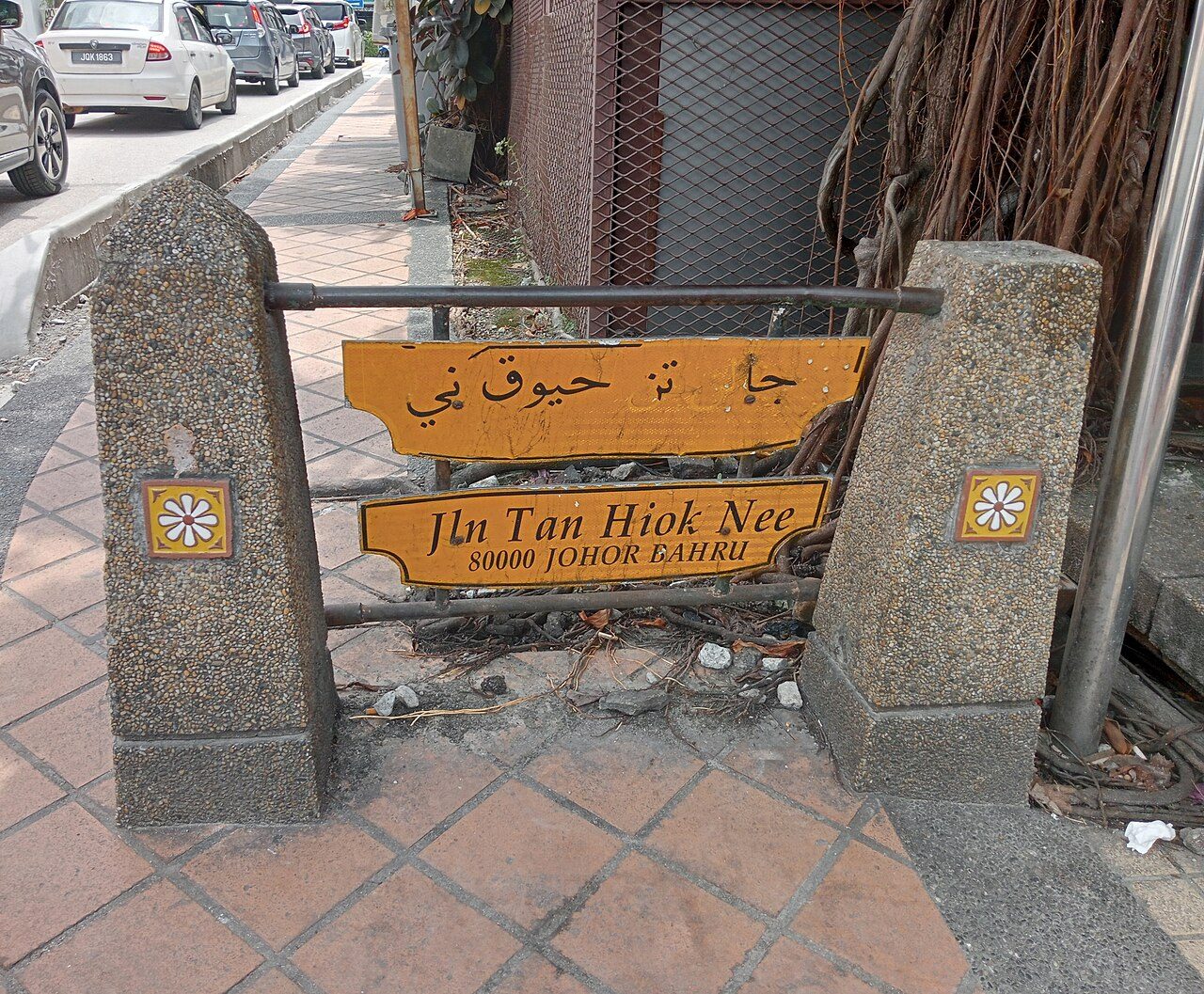 Street sign for Jalan Tan Hiok Nee in Jawi and Roman script, the old-town street where shops sell Johor Bahru local products such as banana cake and biscuits