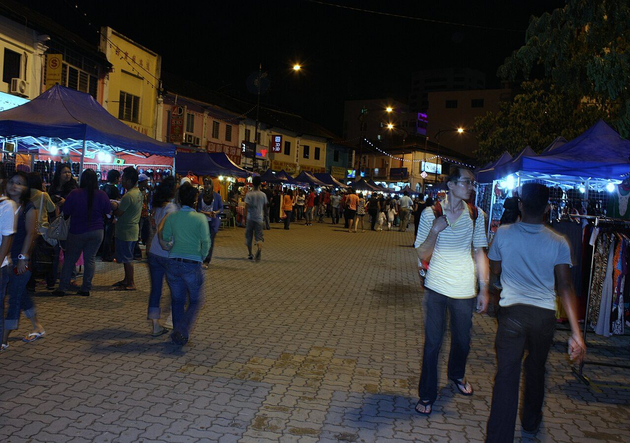 Shoppers walking between lit stall tents at the Bazar JB night market in central Johor Bahru, photographed in 2013 at its earlier site
