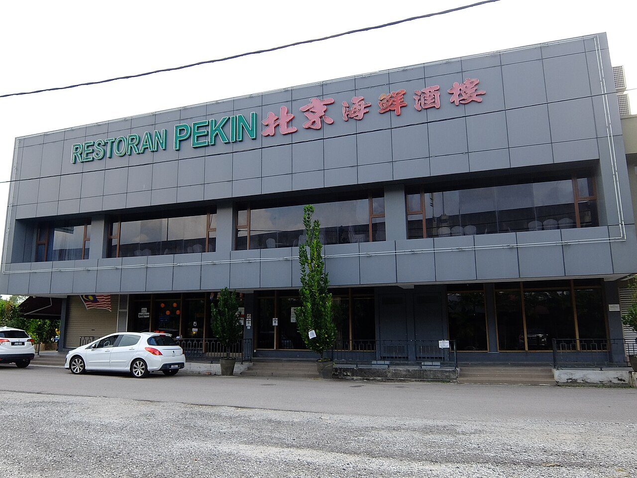 The grey two-storey building of Restoran Pekin in Taman Sentosa, Johor Bahru, with green and red Chinese lettering across the front
