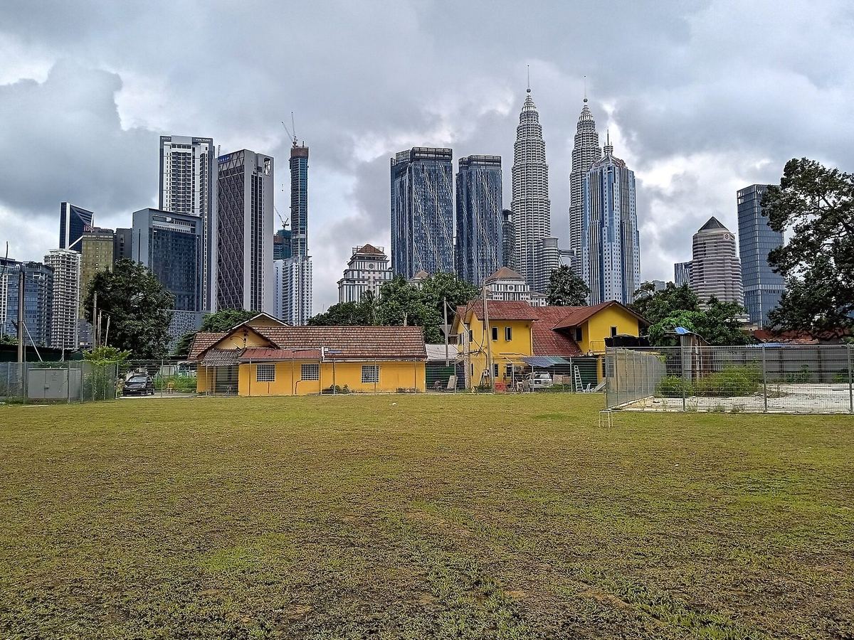 Rumah tradisional Melayu di Kampung Baru dengan Menara Kembar Petronas di belakangnya, Kuala Lumpur