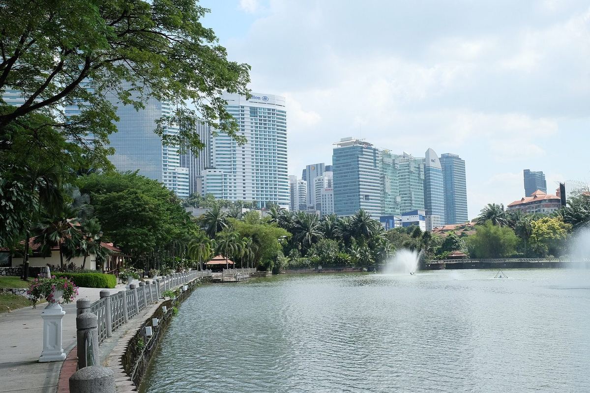 Danau dan air mancur di Taman Botani Perdana dengan cakrawala kota di belakangnya, Kuala Lumpur