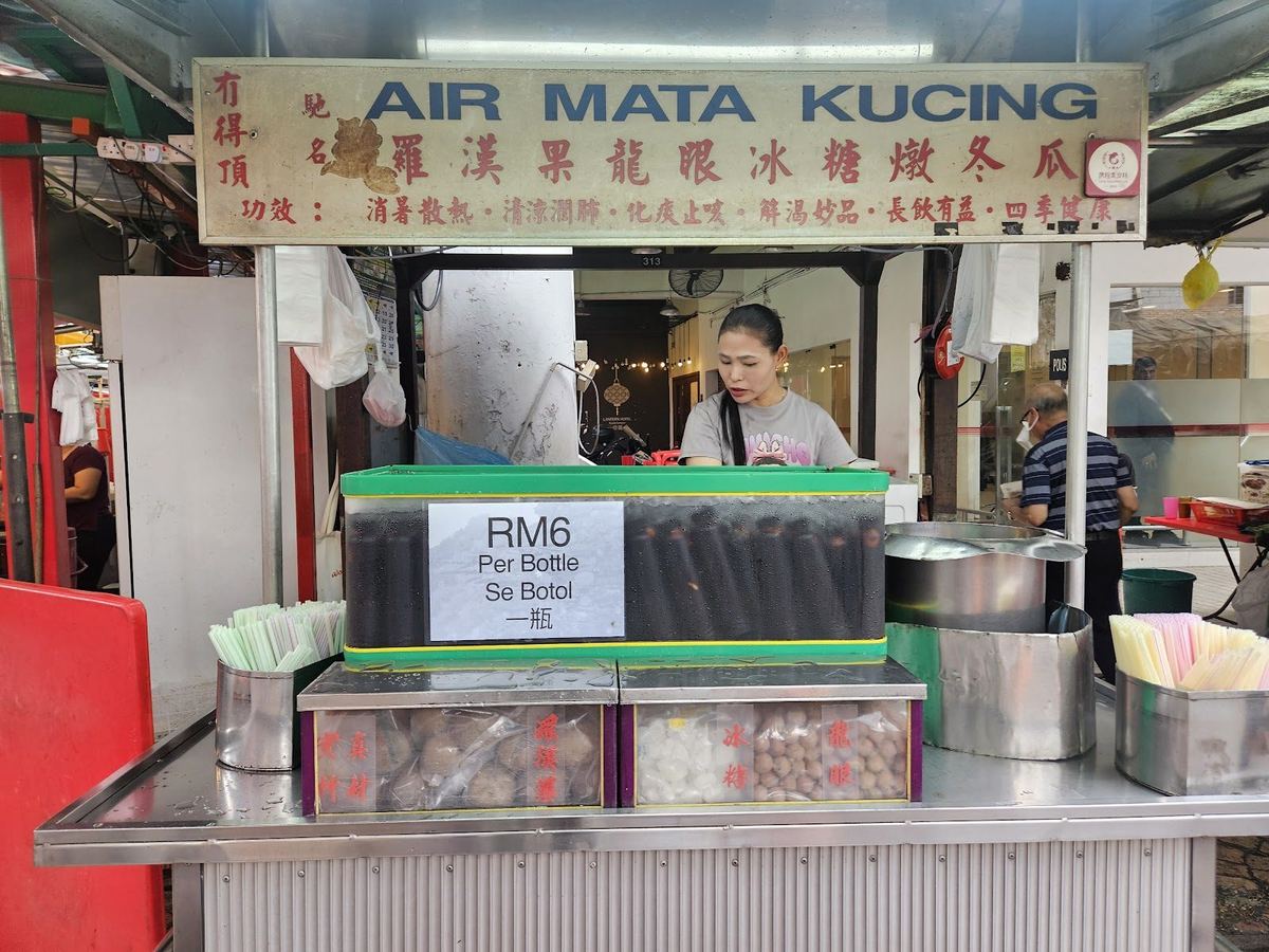 吉隆坡唐人街 Jalan Hang Lekir 上挂着招牌的 Petaling Street Air Mata Kucing 档口