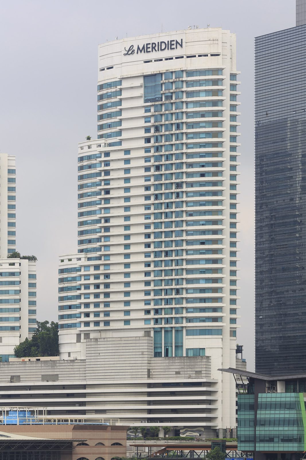 The white Le Méridien Kuala Lumpur tower with its rooftop sign, beside KL Sentral station