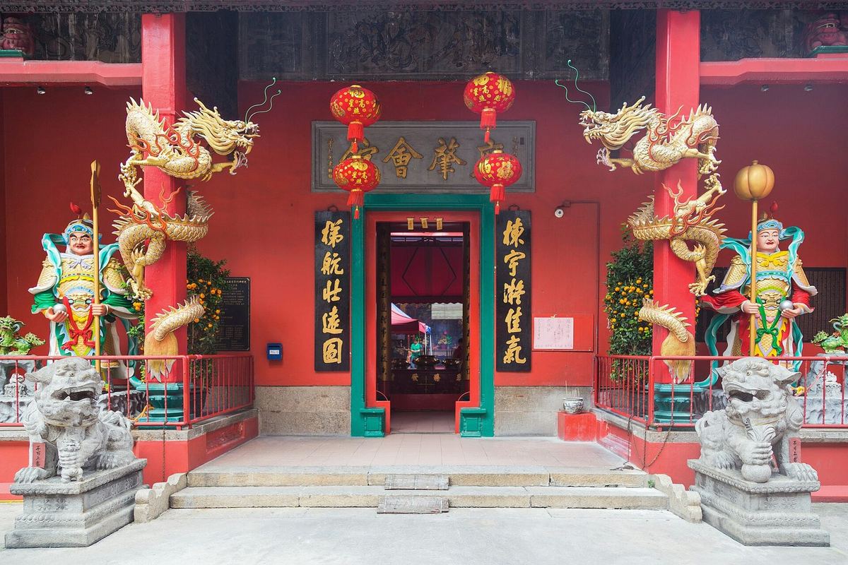 Red entrance of Guan Di Temple on Jalan Tun H.S. Lee, Chinatown, Kuala Lumpur, with dragon pillars and guardians