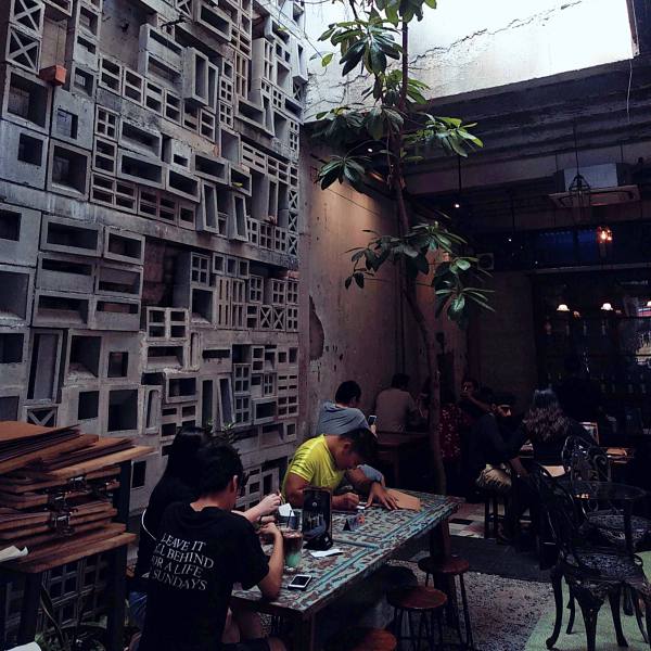唐人街Leaf and Co Cafe庭院里，花砖墙旁树下的座位