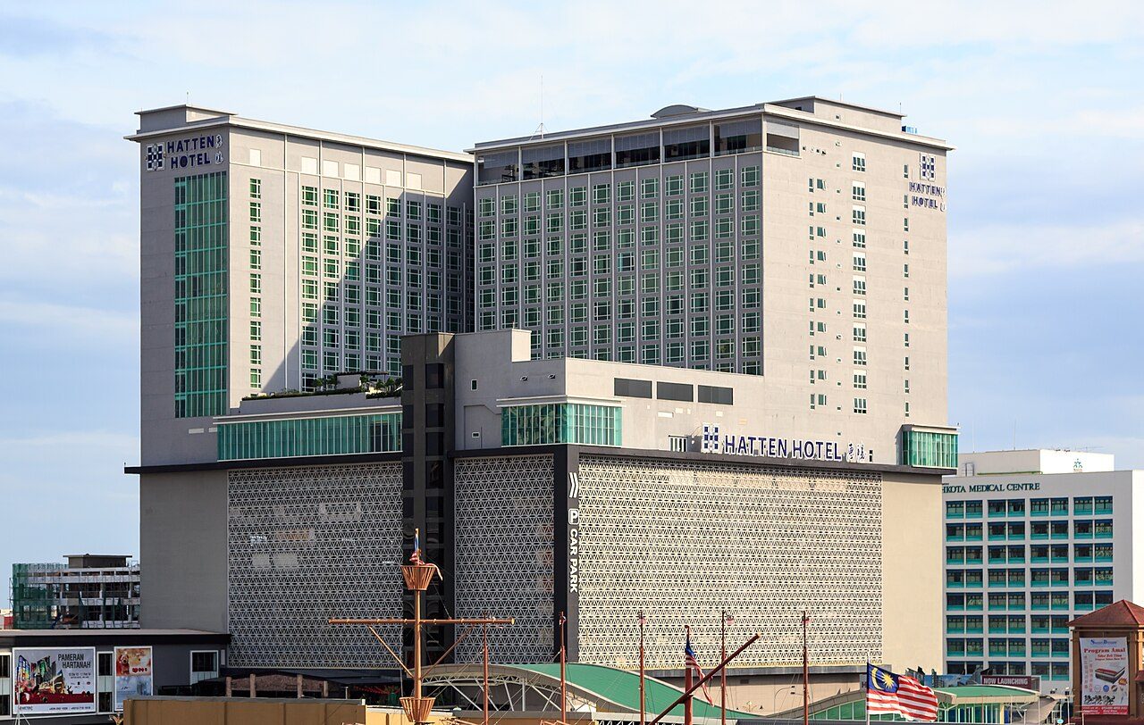The Hatten Hotel towers and podium in Bandar Hilir, Melaka, under a pale sky