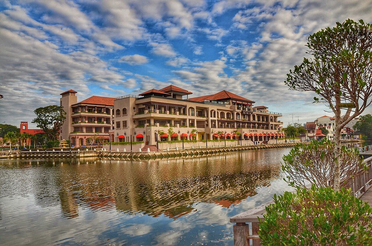 Casa del Rio Melaka, a terracotta-roofed hotel on the bank of the Melaka River, reflected in the water