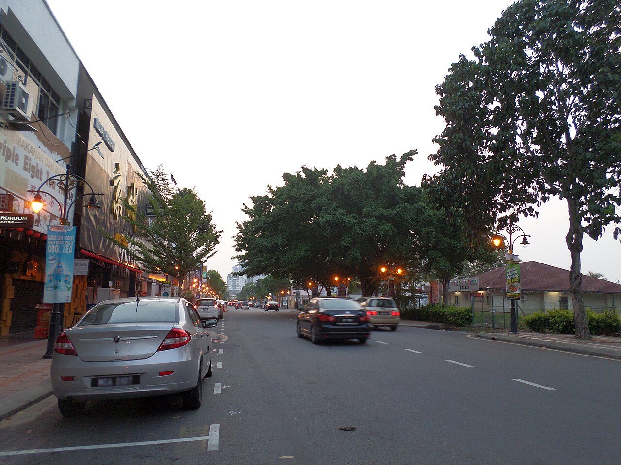 Laundry in Melaka: shoplots and evening traffic on a tree-lined street in Melaka Raya, the area where Cleanpro Express Melaka Raya is