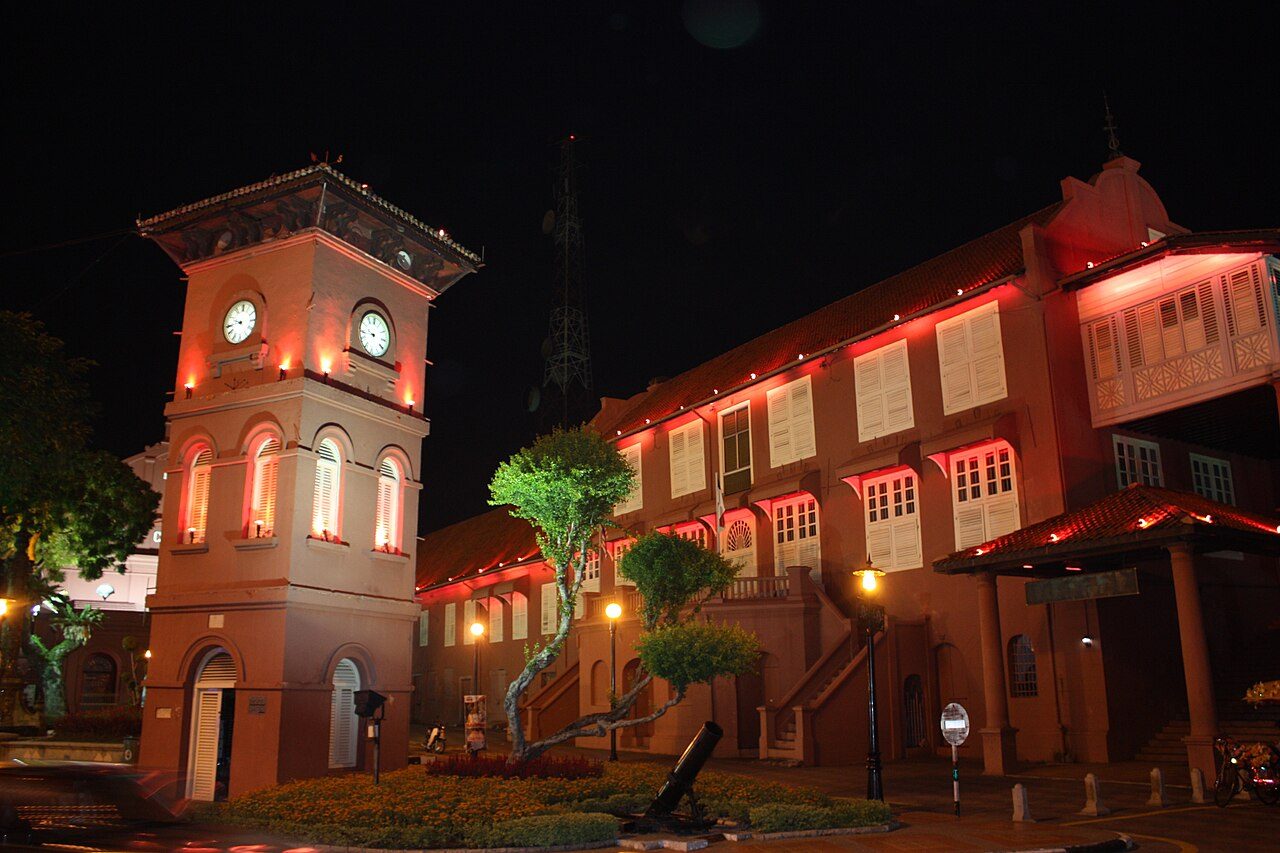 The red Stadthuys and clock tower in Banda Hilir, Melaka, lit up at night, photographed in 2009