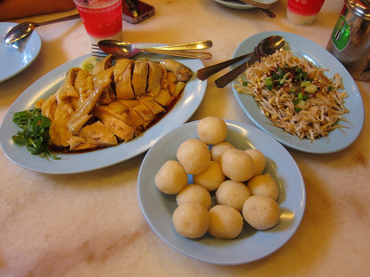 Melaka restaurants: a plate of chicken rice balls with poached chicken and bean sprouts on a marble table in Melaka