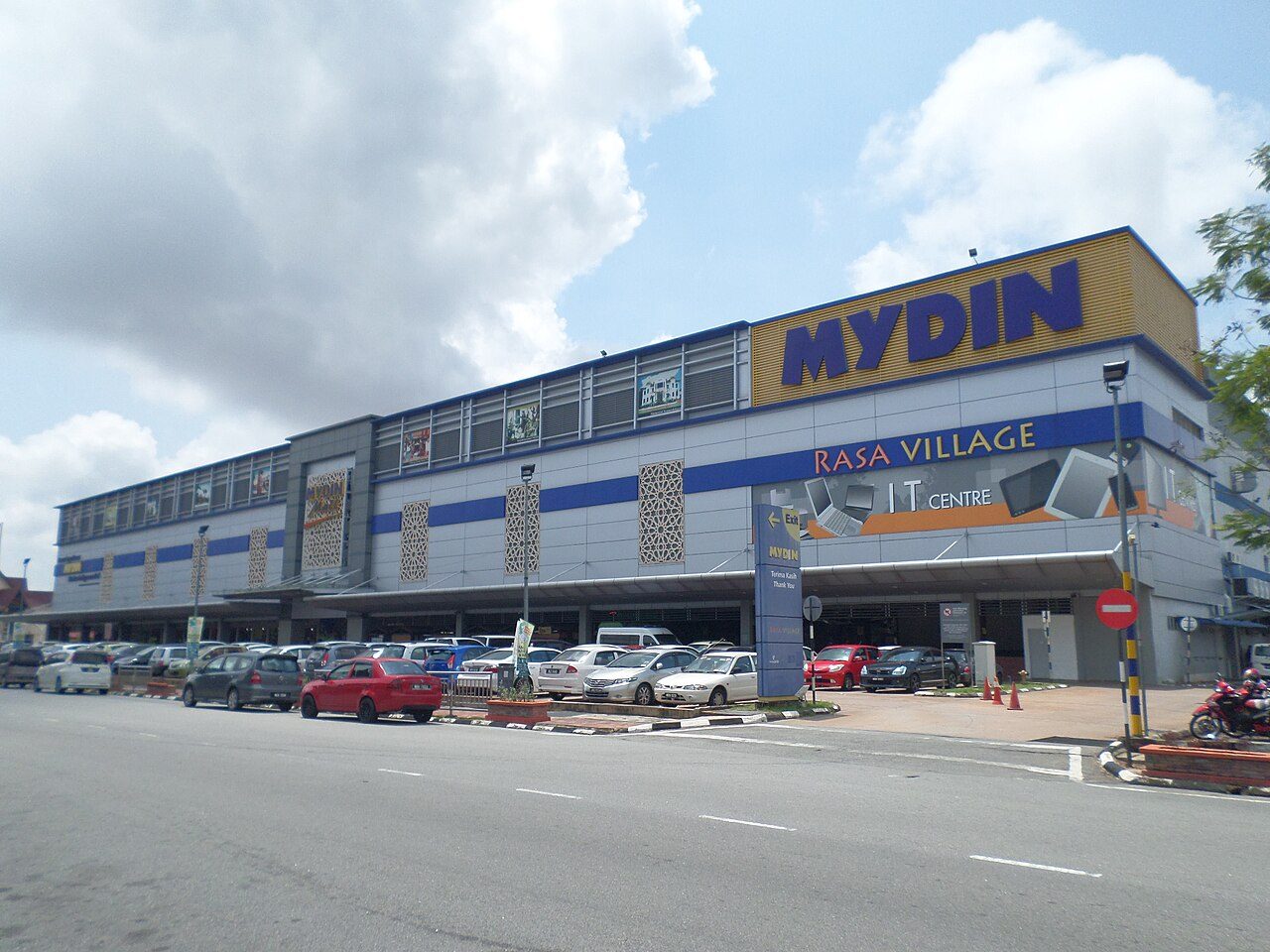 The long grey and blue Mydin mall building in Ayer Keroh with a large yellow Mydin sign and a car park in front