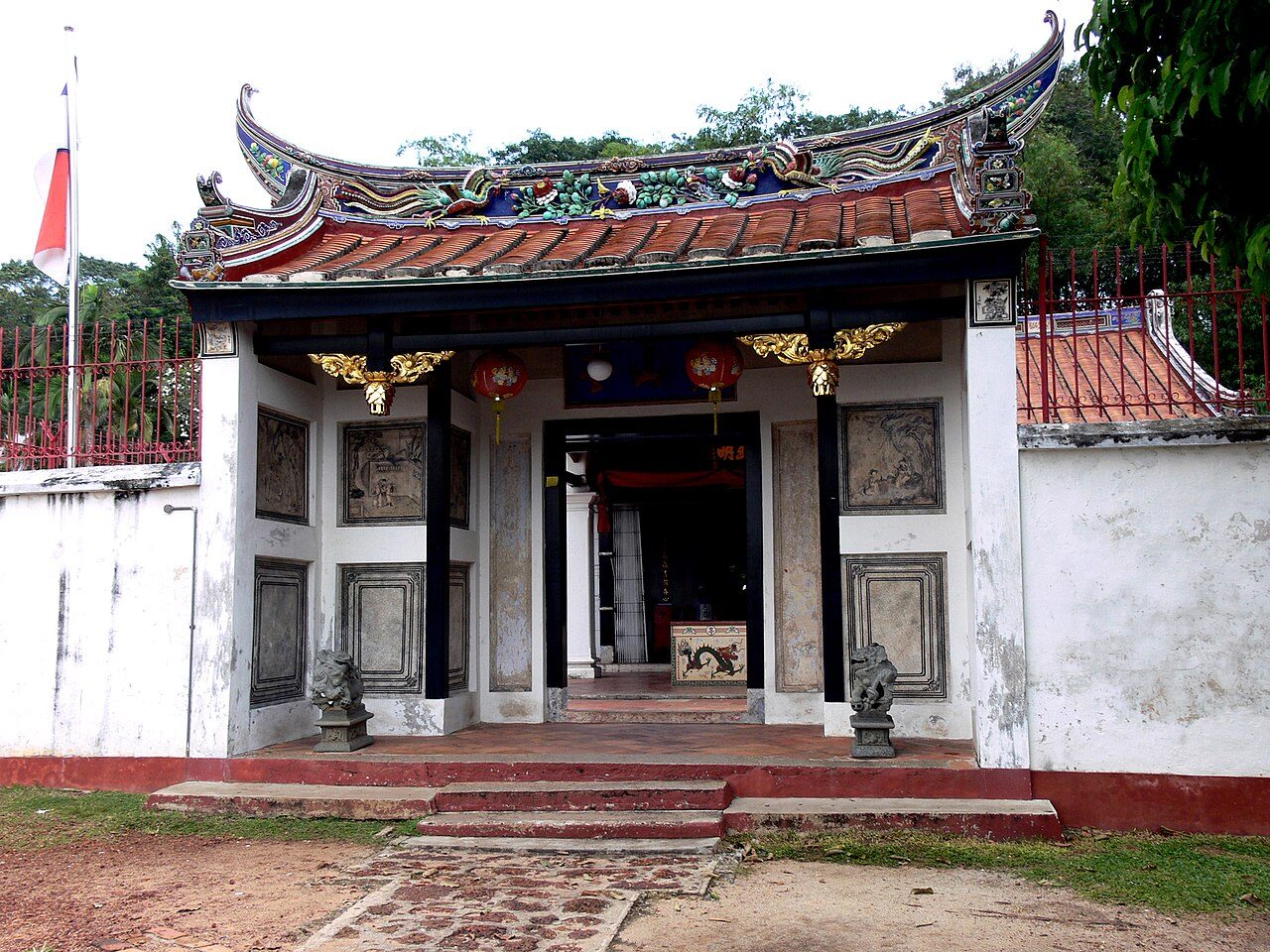 The small Poh San Teng temple at the foot of Bukit China with a curved, decorated Chinese roof and white walls