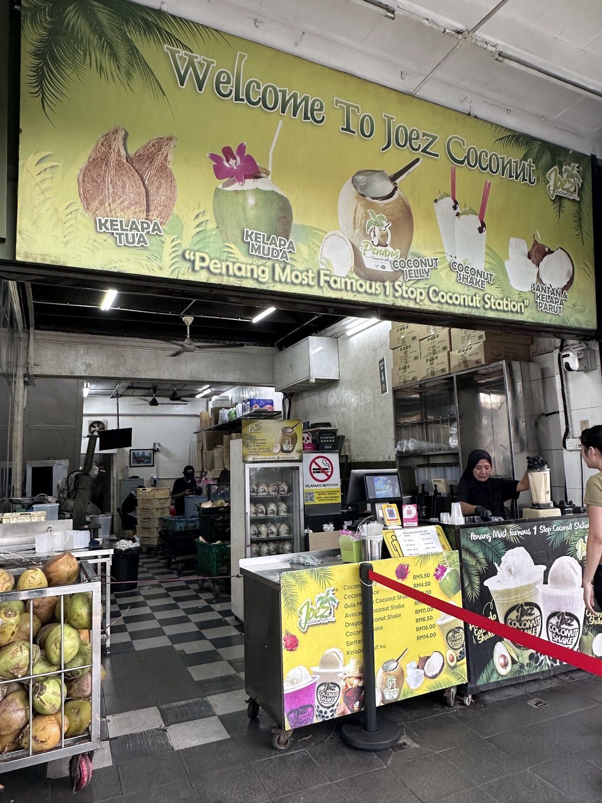 槟城乔治市 Jalan Dato Keramat 上摆满椰子、挂着招牌的 Joe'z Coconut 柜台