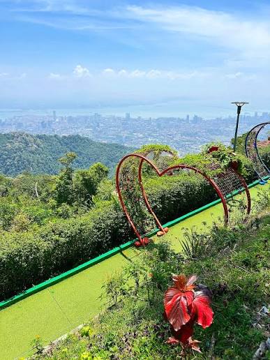 Gerbang berbentuk hati di taman puncak Bukit Bendera dengan George Town di bawah