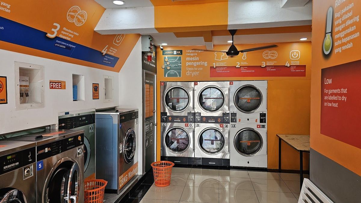 槟城乔治市 Jalan Argyll 上 Laundry Hub 自助洗衣店内的洗衣机和叠放的烘干机