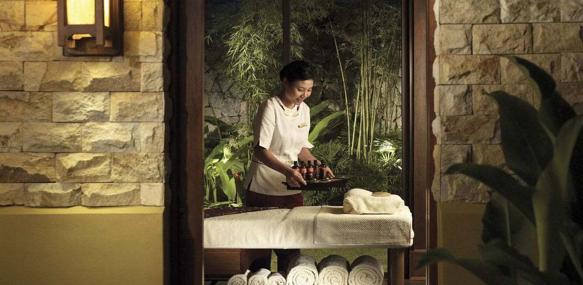 峇都丁宜 Shangri-La Rasa Sayang 的 CHI, The Spa 内，理疗师正在准备护理室，槟城水疗与按摩