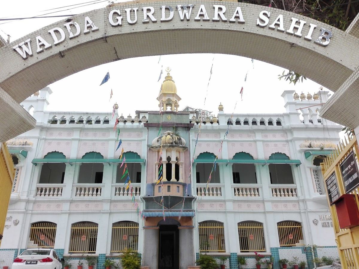 White facade of Wadda Gurdwara Sahib seen through its name arch on Jalan Gurdwara, George Town, Penang