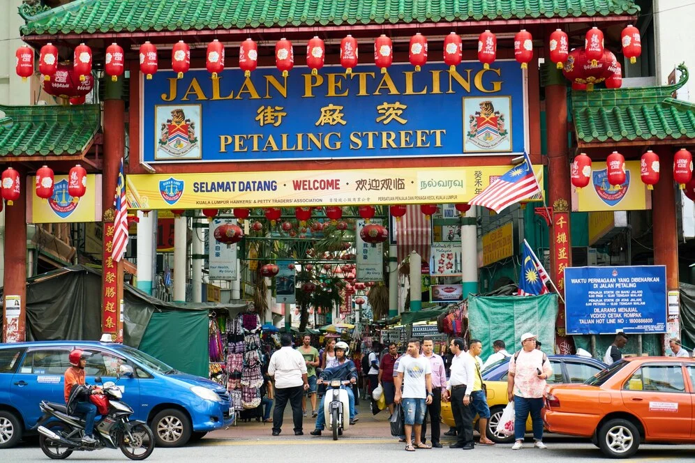 吉隆坡唐人街挂着灯笼的茨厂街牌楼，车流与购物人潮
