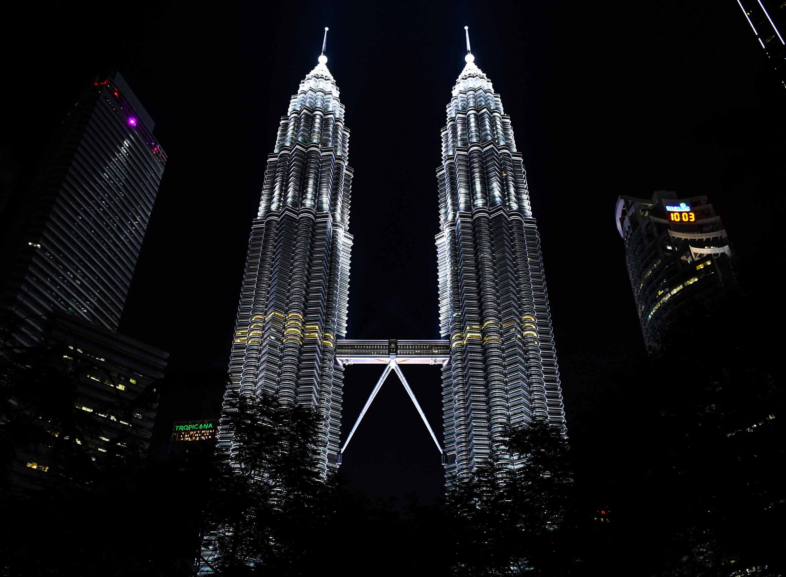 Menara Berkembar Petronas bercahaya pada waktu malam dengan Jambatan Langit di antaranya