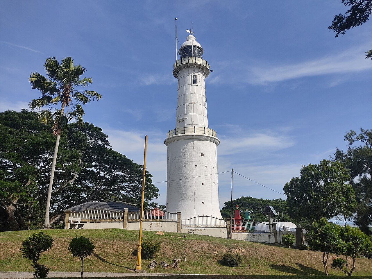 The white lighthouse on Bukit Melawati, Kuala Selangor, with trees around it