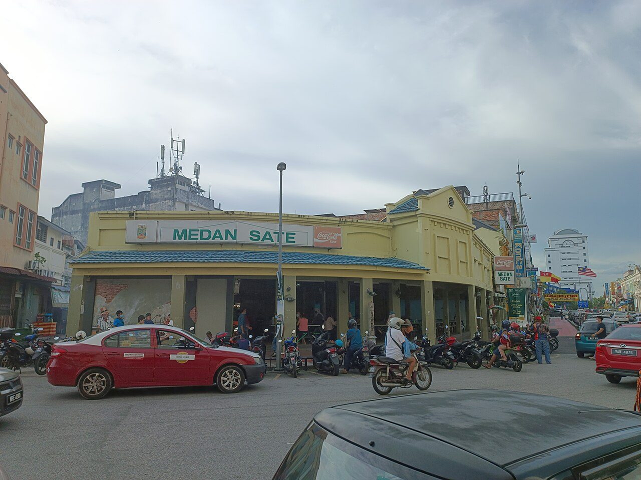 Medan Sate, a corner shophouse restaurant with a green sign in Kajang town centre, the home of satay Kajang, with motorbikes parked outside