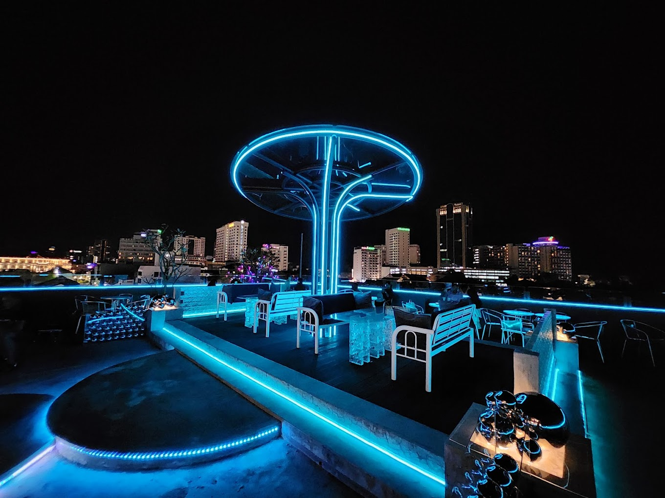 夜晚的 Sphere Rooftop Bar 露台，蓝色霓虹顶篷、休闲座椅，背后是乔治市建筑