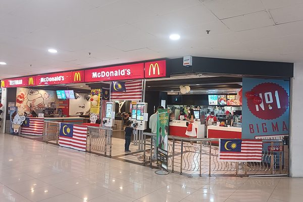 McDonalds counter in a Penang mall decked with Malaysian flags, picturing the McD App Birthday Fiesta