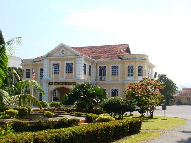 Cream-coloured colonial building of the Darul Ridzuan Museum with a landscaped garden in front
