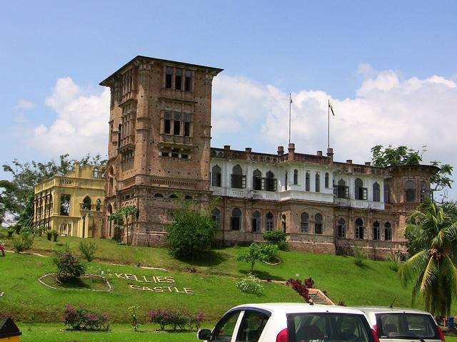 Kellie's Castle in Batu Gajah, a large unfinished mansion with a tall tower seen from the lawn