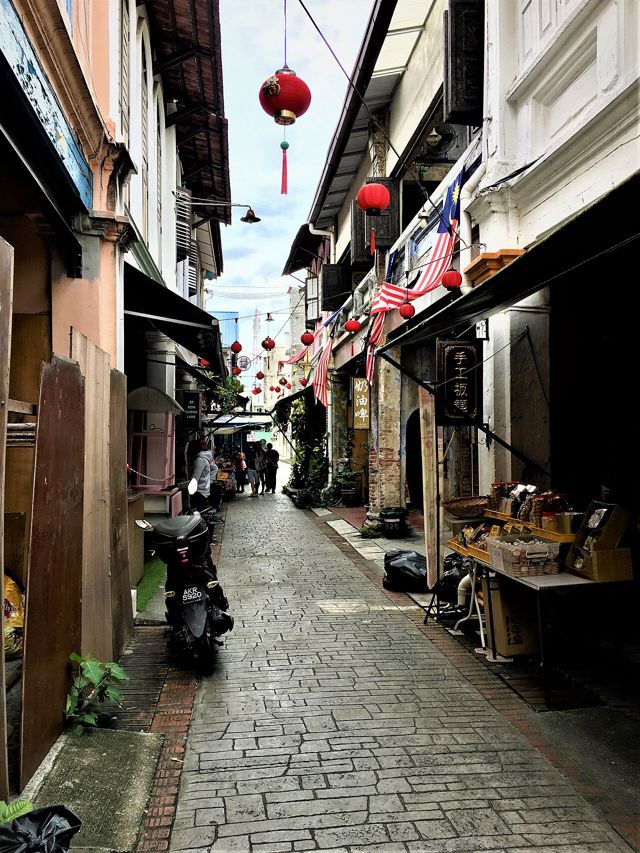 Concubine Lane in Ipoh Old Town with red lanterns and a snack stall