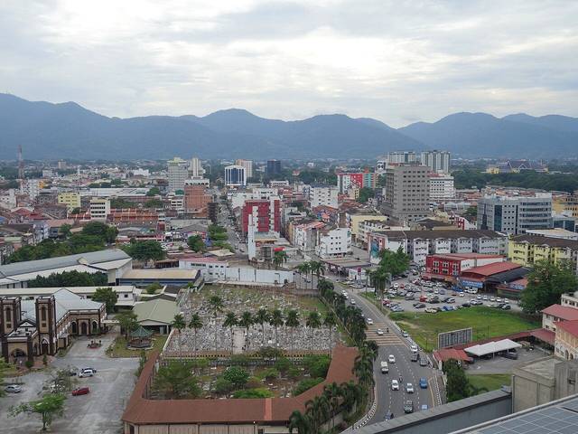 Ipoh bars guide: daytime view over central Ipoh showing city streets, rooftops and the limestone hills behind