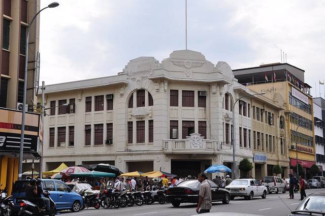 Ipoh nightclubs guide: white Art Deco heritage building on a busy street in central Ipoh, photographed in daytime