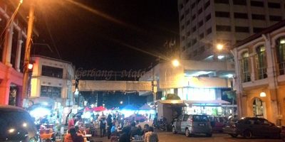 Gerbang Malam arch over a street of stalls and diners at night, one of the night markets in Ipoh