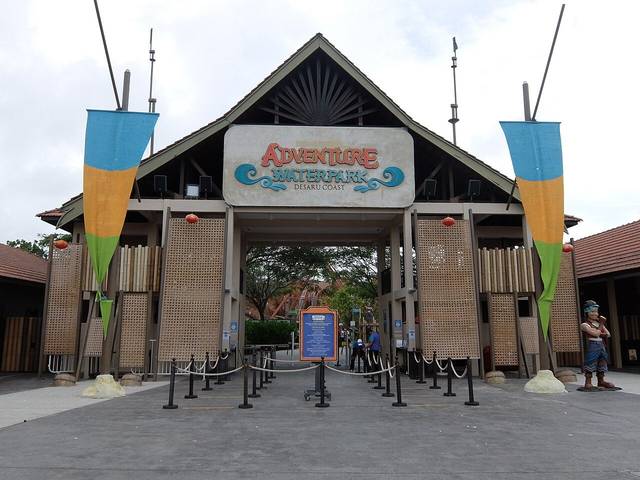 The timber gateway of the Adventure Waterpark Desaru Coast, with tall coloured banners on either side