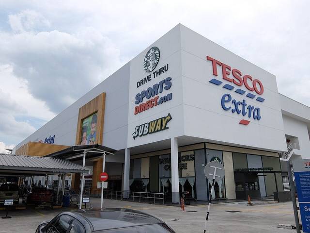 The hypermarket at Desa Tebrau in 2019, when it was still branded Tesco Extra, with Starbucks drive-thru, Sports Direct and Subway signs