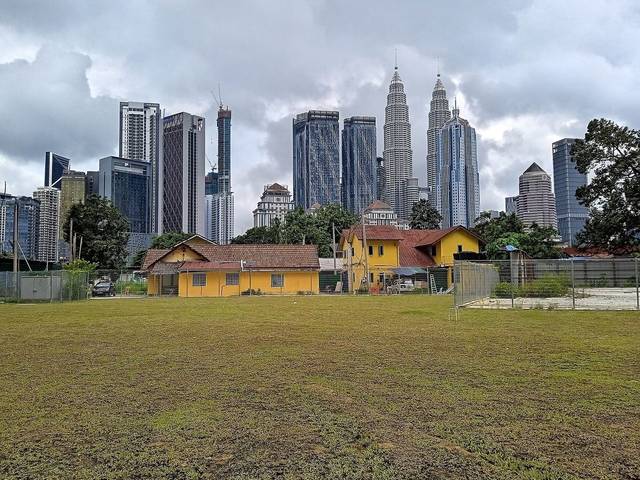 Traditional Malay houses in Kampung Baru with the Petronas Twin Towers behind, Kuala Lumpur