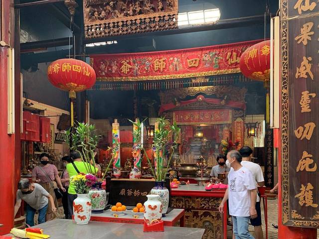 Worshippers at the red and gold altar inside Sin Sze Si Ya Temple, Chinatown, Kuala Lumpur