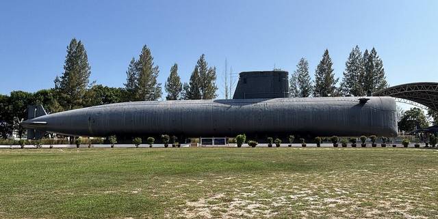The black hull of the FS Ouessant submarine on display on a lawn at Klebang, Melaka