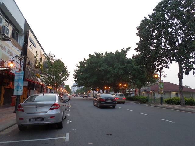 Laundry in Melaka: shoplots and evening traffic on a tree-lined street in Melaka Raya, the area where Cleanpro Express Melaka Raya is