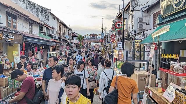 Crowds walking past stalls and shophouses on Jonker Street during the evening night market in Melaka